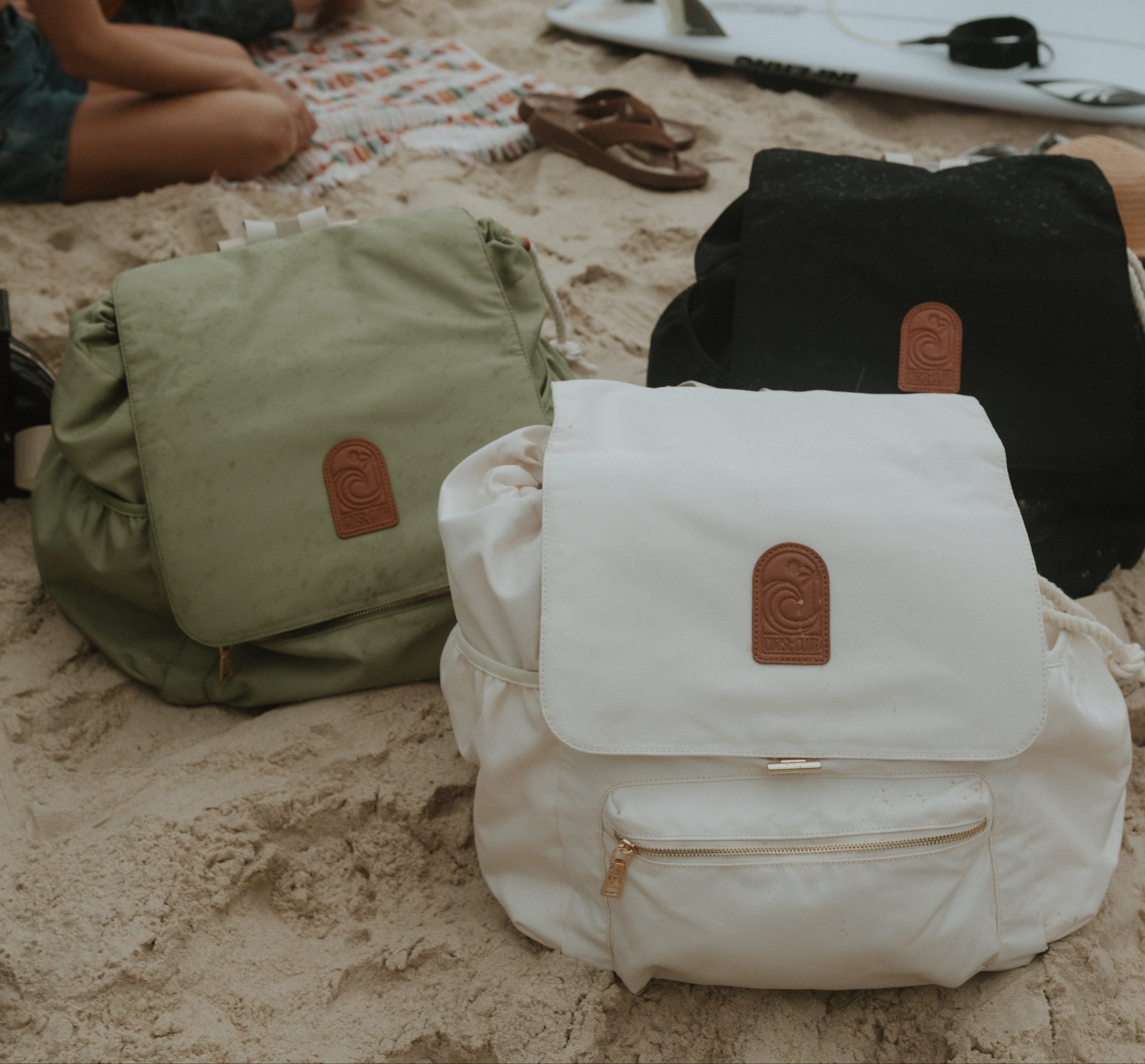 All three coloured backpacks on beach