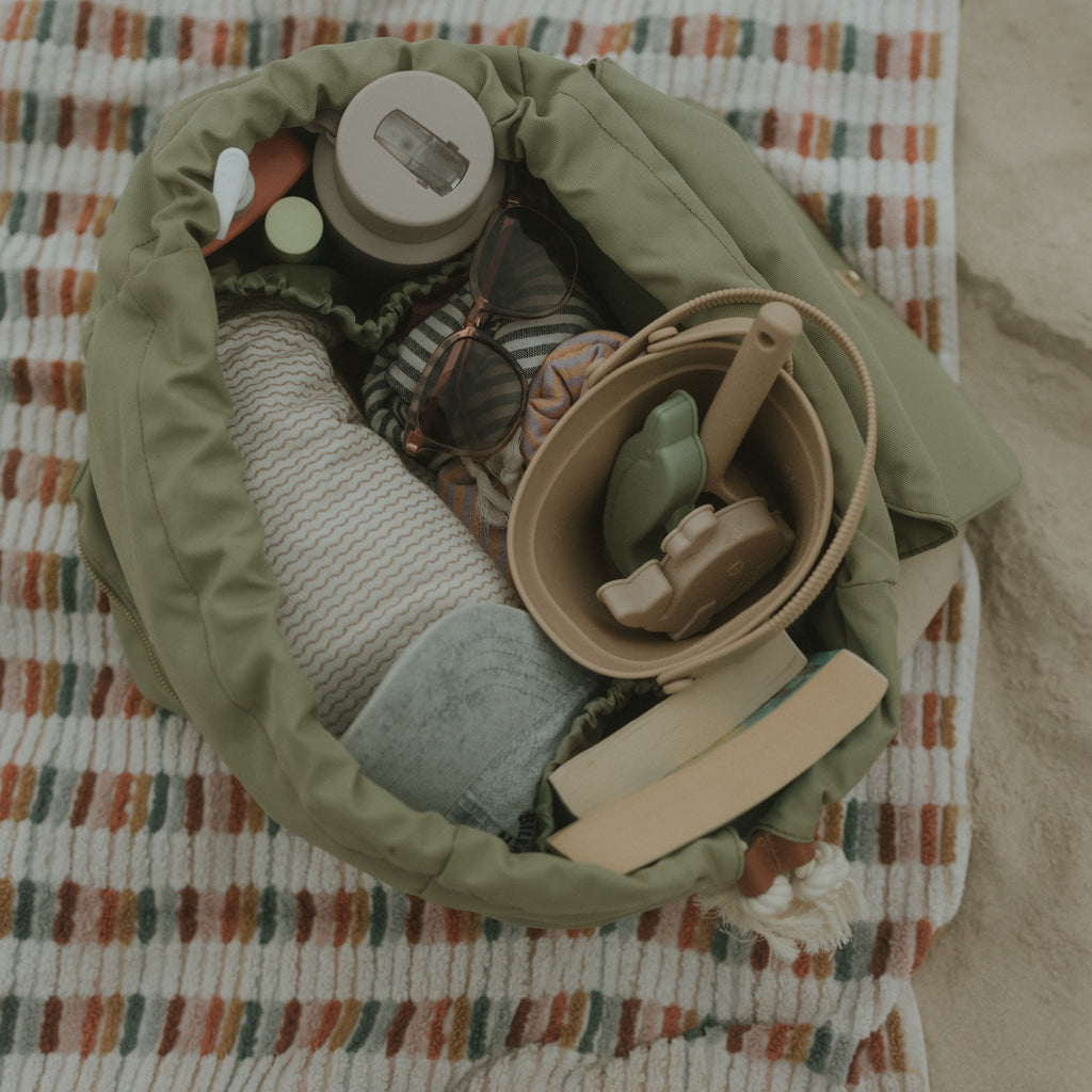 Sage oversized backpack with kids bucket set and towels on a textured blanket