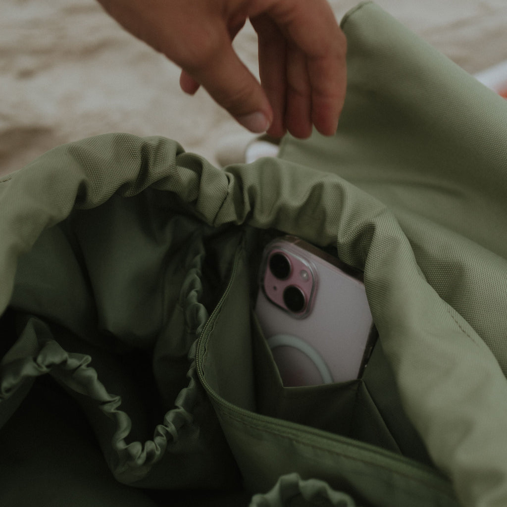 Hand reaching into a sage bag on a sandy background